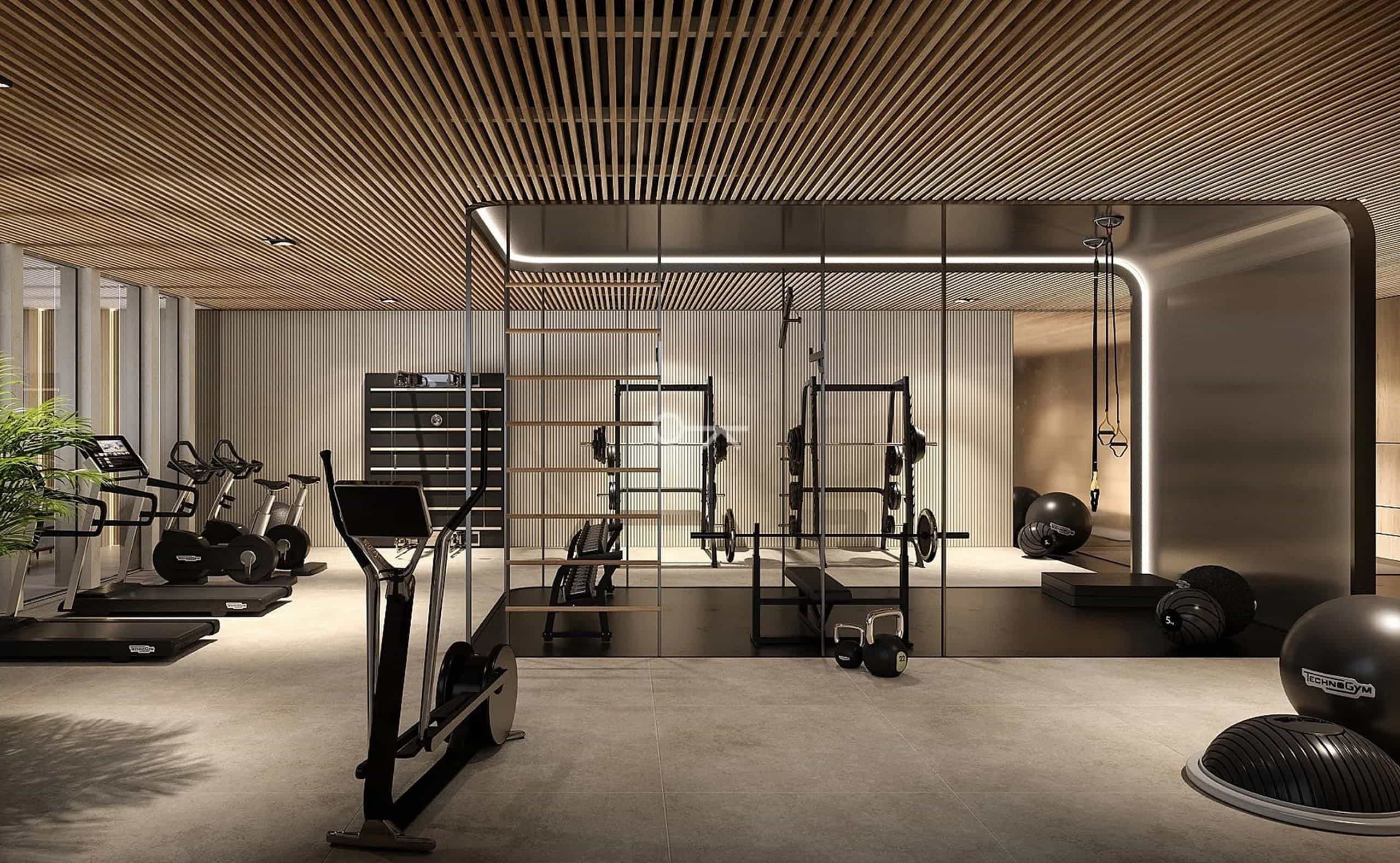 Modern, well-lit gym with sleek equipment, treadmills, weights, and glass partitions.