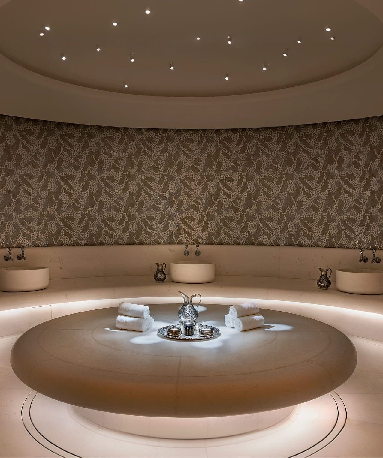 Luxurious circular room with a central illuminated water feature and star-lit ceiling.