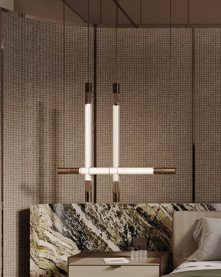 Modern linear pendant light with glowing bars above a luxurious marble headboard.