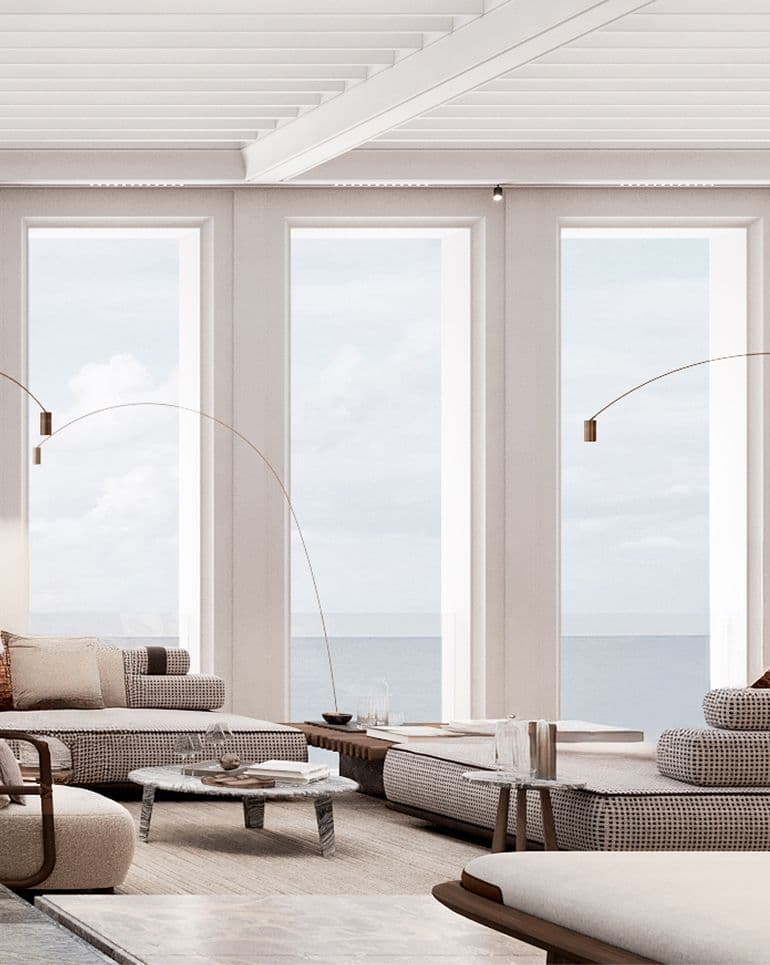 Modern living room with large windows, modular sofas, and a serene ocean view.